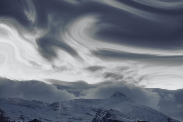 Clouds above a snowy mountain.
