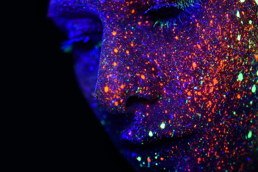 Face covered in glow-in-the-dark paint.