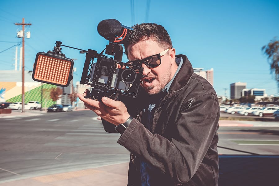 Man holding a large film camera.